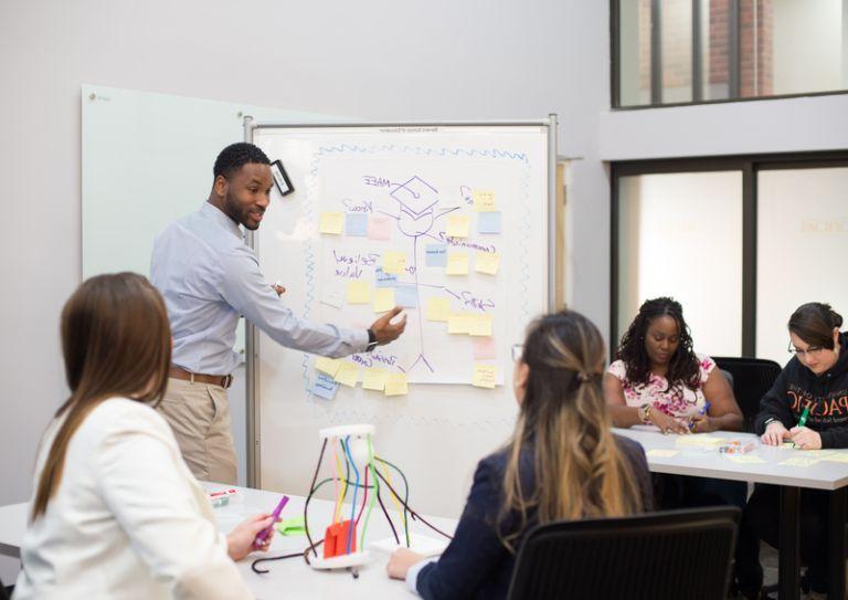 students interact with professor in classroom